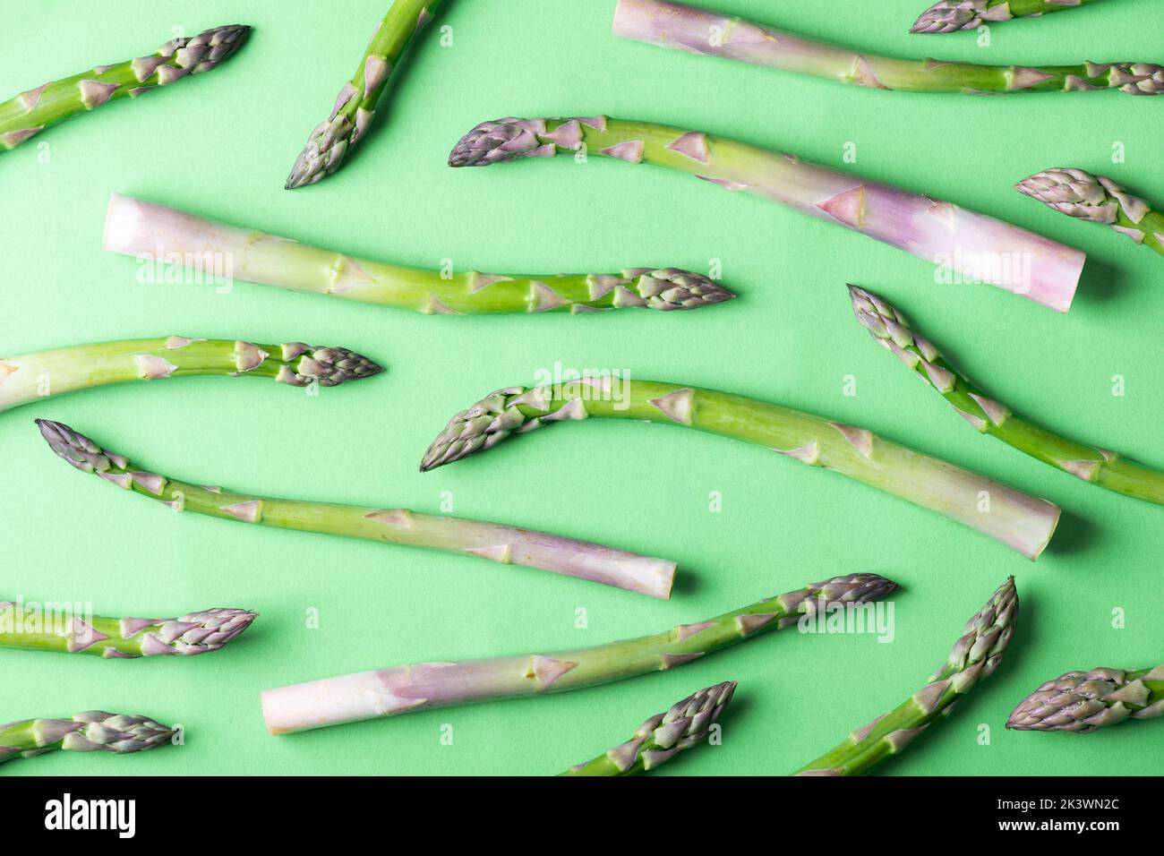 Fresh asparagus pattern. Creative background of asparagus on green. Healthy food concept. Top view, flat lay Stock Photo