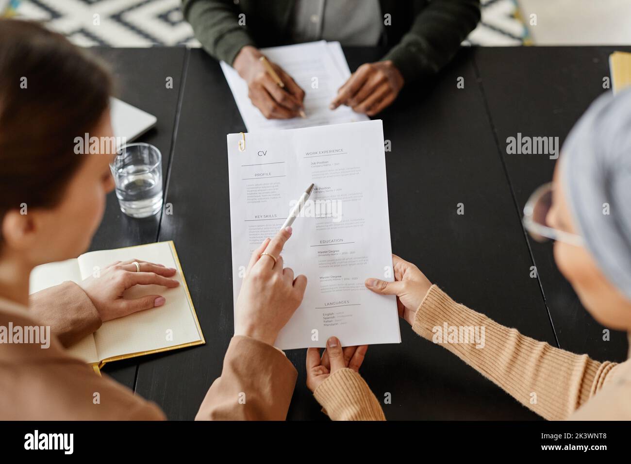 High angle close up of two female HR managers holding CV of candidate at job interview Stock Photo