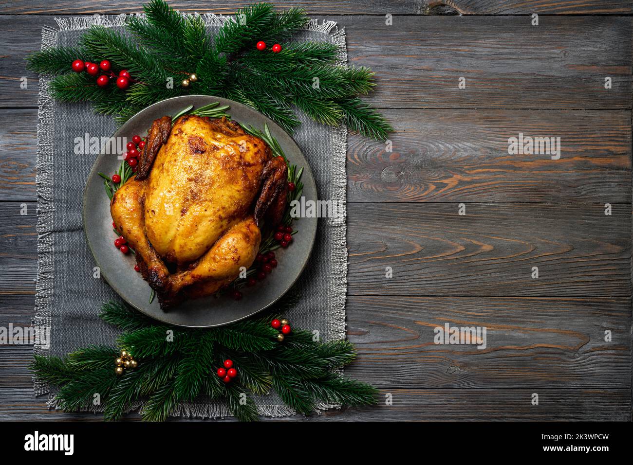 Chrismas chicken baked with cranberry and rosemary for Christmas dinner, festive holiday dish top view. Christmas decoration served table. Copy space Stock Photo