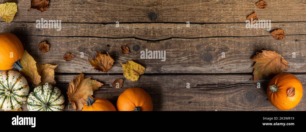 Autumn composition from pumpkins and autumn leaves on wooden background. Concept of Thanksgiving day or Halloween. Autumn background with copy space Stock Photo