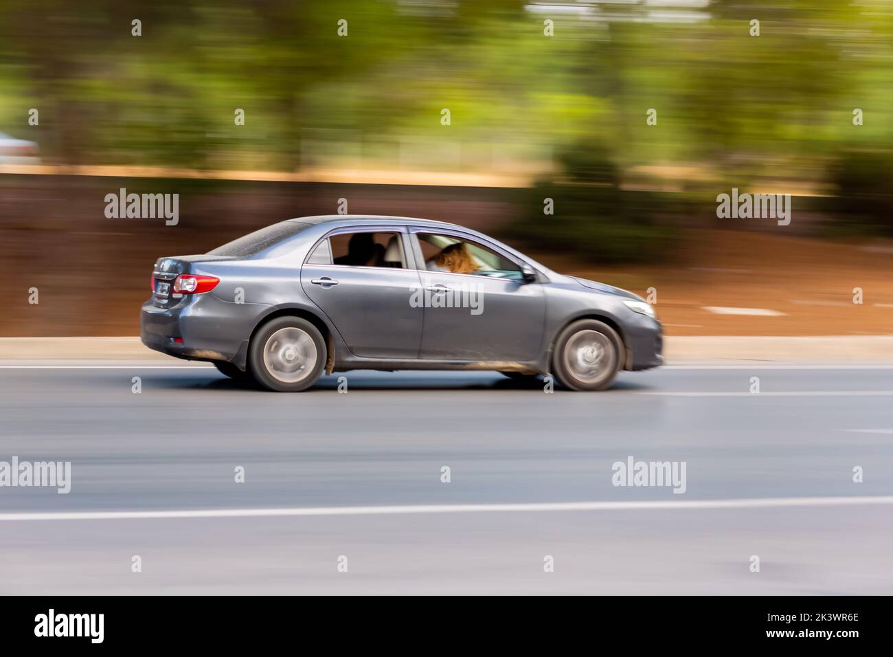 Panning shot of a car driving on a highway. Blurred photo. Stock Photo