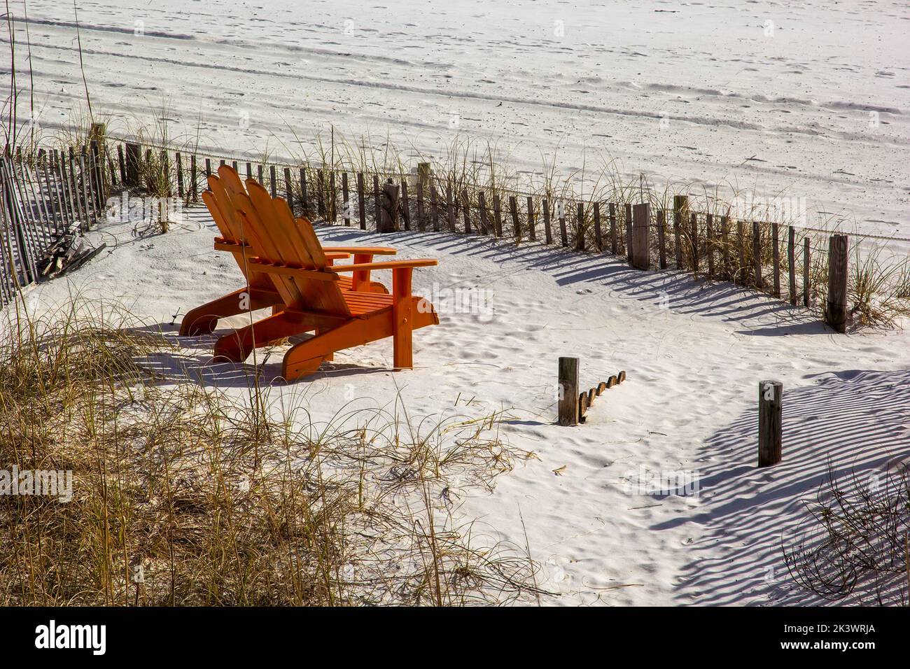 Pair of orange Adirondack leisure chairs on the beach in Destin, Florida Stock Photo