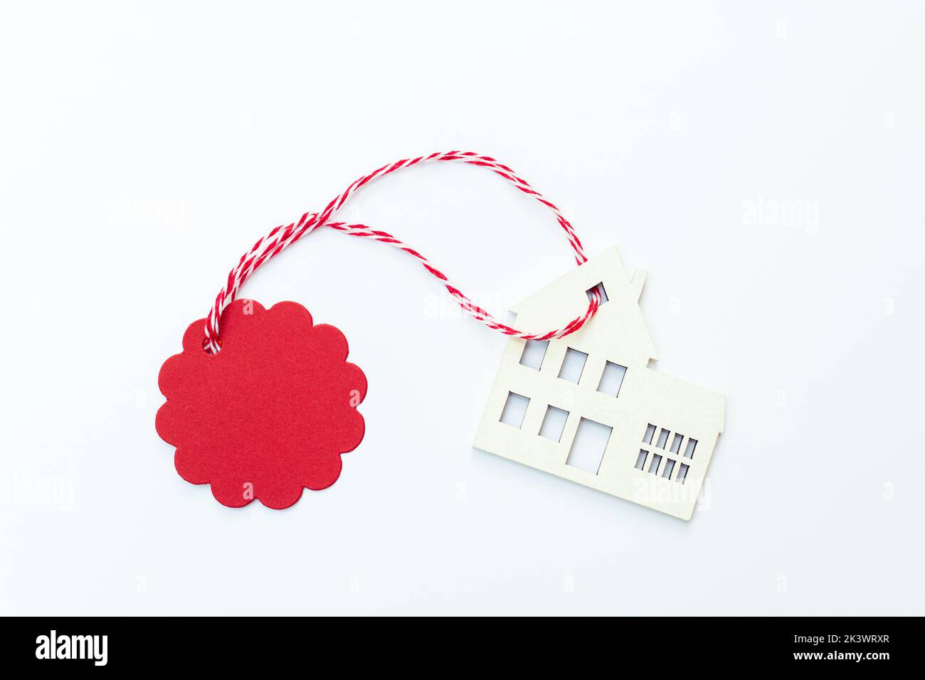 House for buy or rent label on winter holidays. Wooden house symbol with tag on white background. Real estate, rental housing, rent for christmas holi Stock Photo
