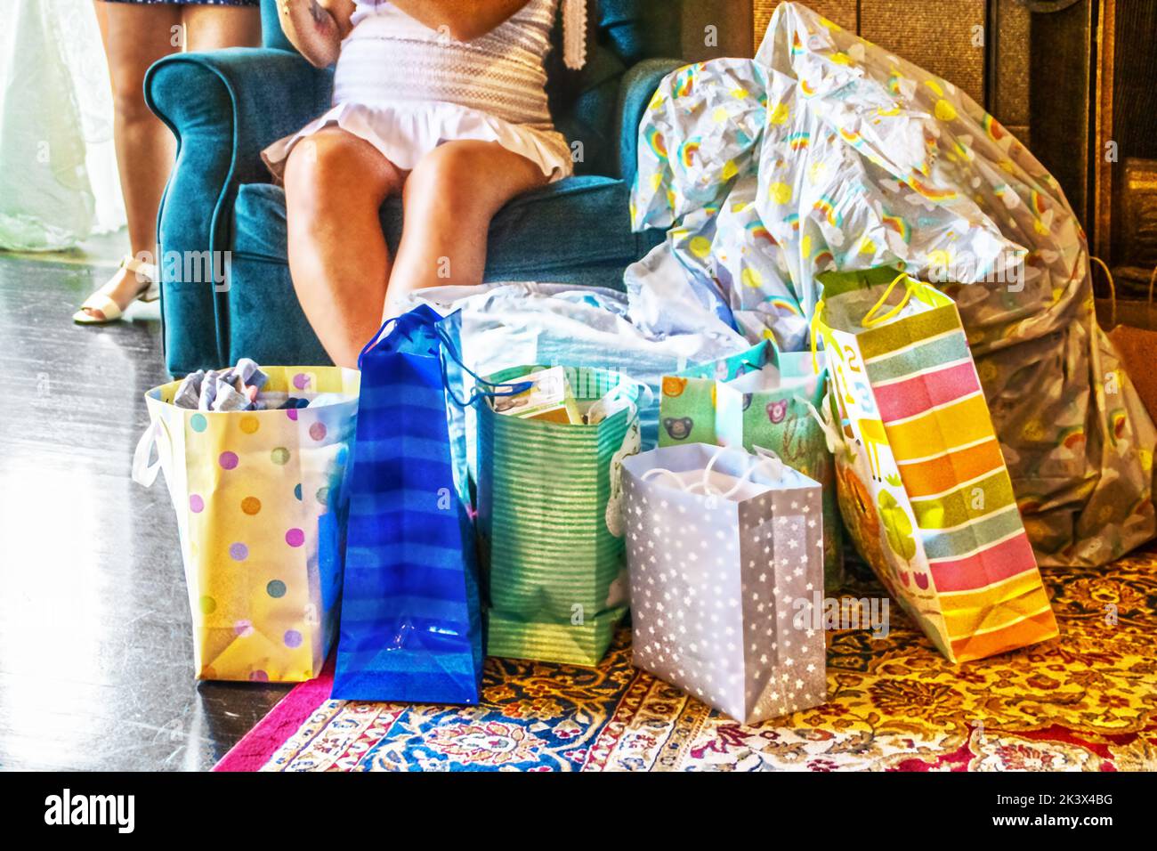 Baby shower with mother to be surrounded by gifts - cropped Stock Photo