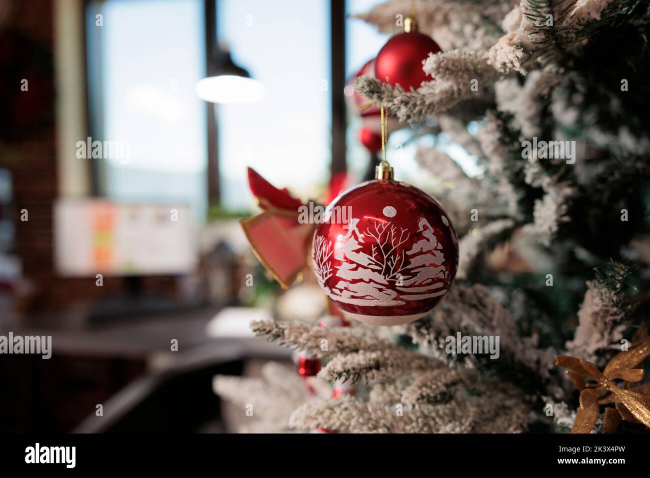 Festive christmas tree in empty business office, decorated with xmas bulbs, bauble, garlaand and tinsel to celebrate seasonal winter holiday. Startup workplace with ornaments and decor. Close up. Stock Photo