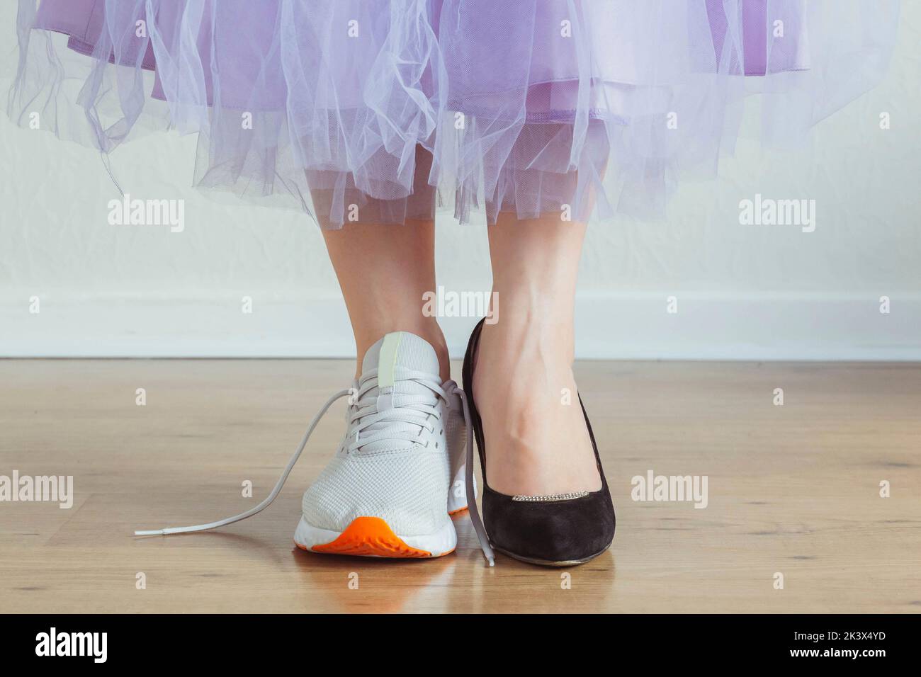 Woman choosing what to wear - sneakers or dress shoes Stock Photo