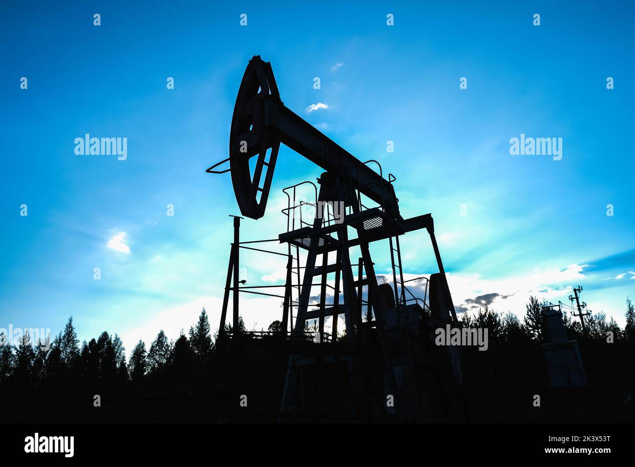 An abandoned oil or gas rocking machine against a blue sky, exhausted