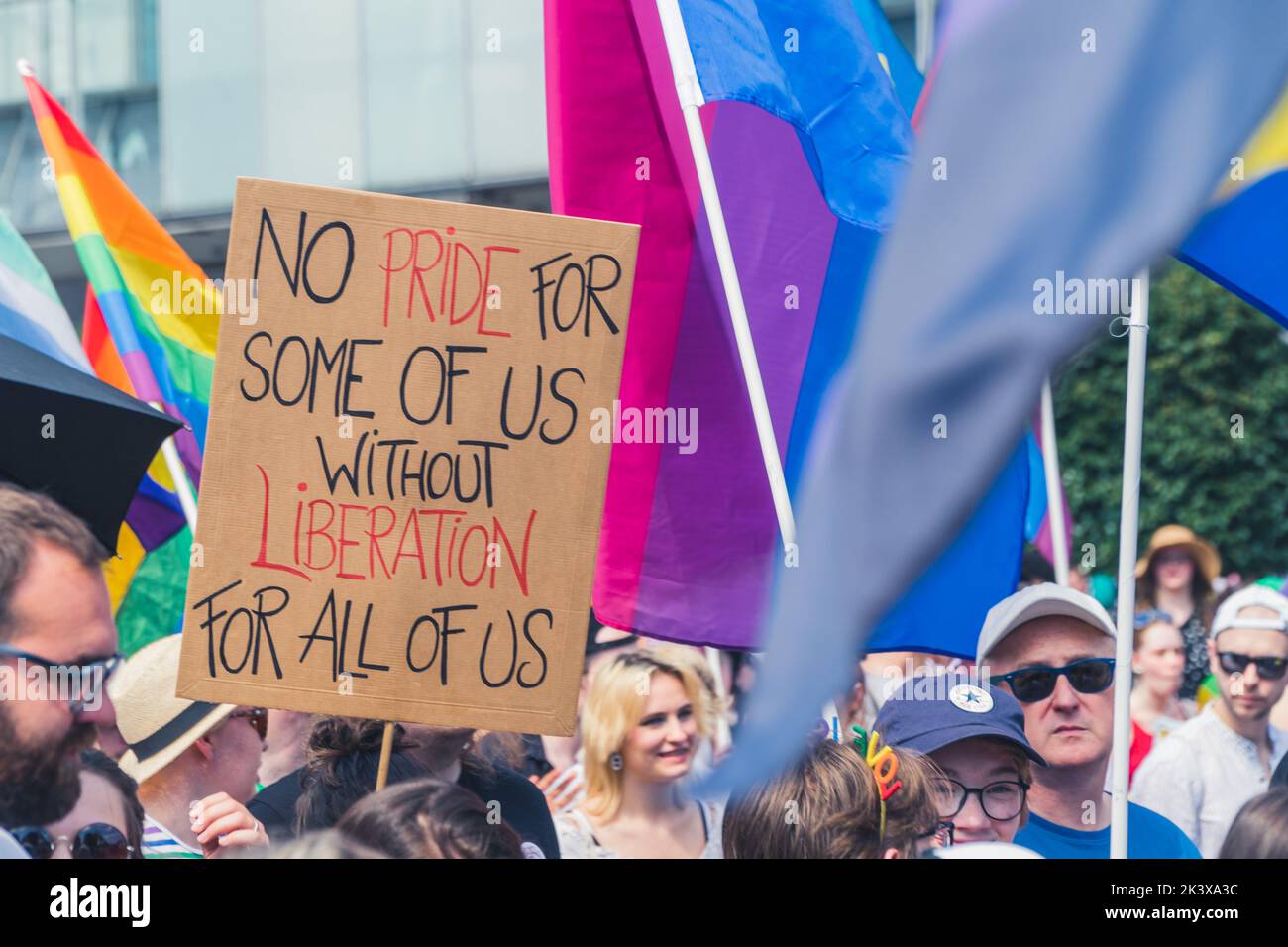 June 25, 2022 Warsaw, Poland - Diverse people marching with protest signs and colorful flags in support of lgbtq people. Equality march of the Warsaw Equality Parade 2022 and KyivPride. High quality photo Stock Photo