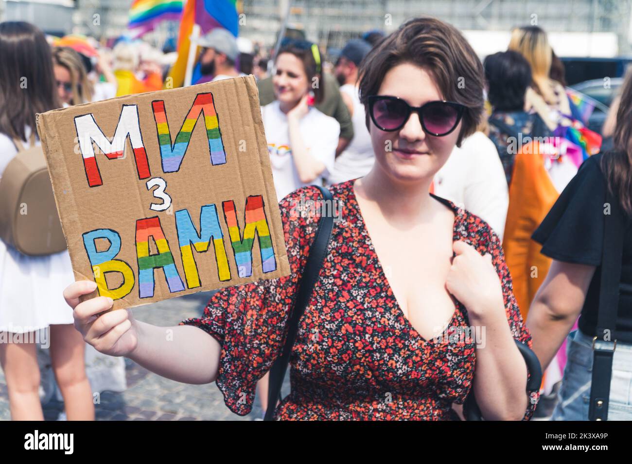 June 25, 2022 Warsaw, Poland - A woman holds a placard saying - We are with you. This year the Warsaw Equality Parade hosted the Kyiv Pride - the largest Ukraine's LGBTQ rights parade. Participants showed their support against the war and Russia's invasion of Ukraine. Stock Photo