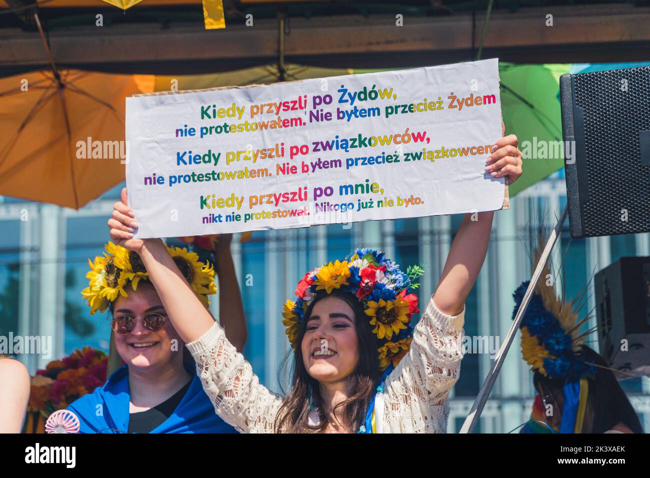 June 25, 2022 Warsaw, Poland - The Warsaw Equality Parade hosted the Kyiv Pride. Girls wearing Ukrainian national flower crowns, holding a powerful protest placard in support of Ukraine and the LGBTQ community. High quality photo Stock Photo