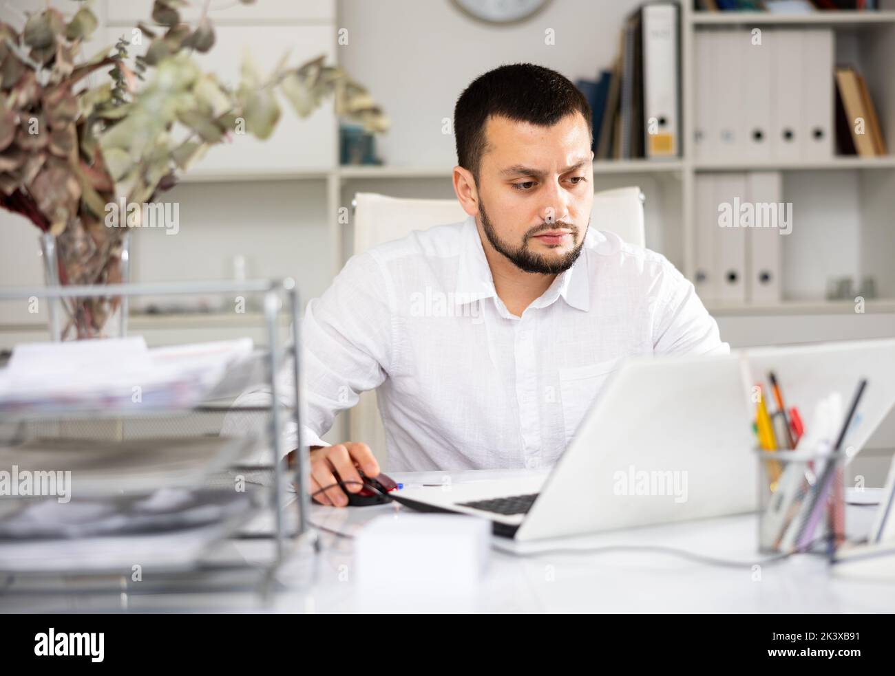 Man office worker using laptop during workday Stock Photo