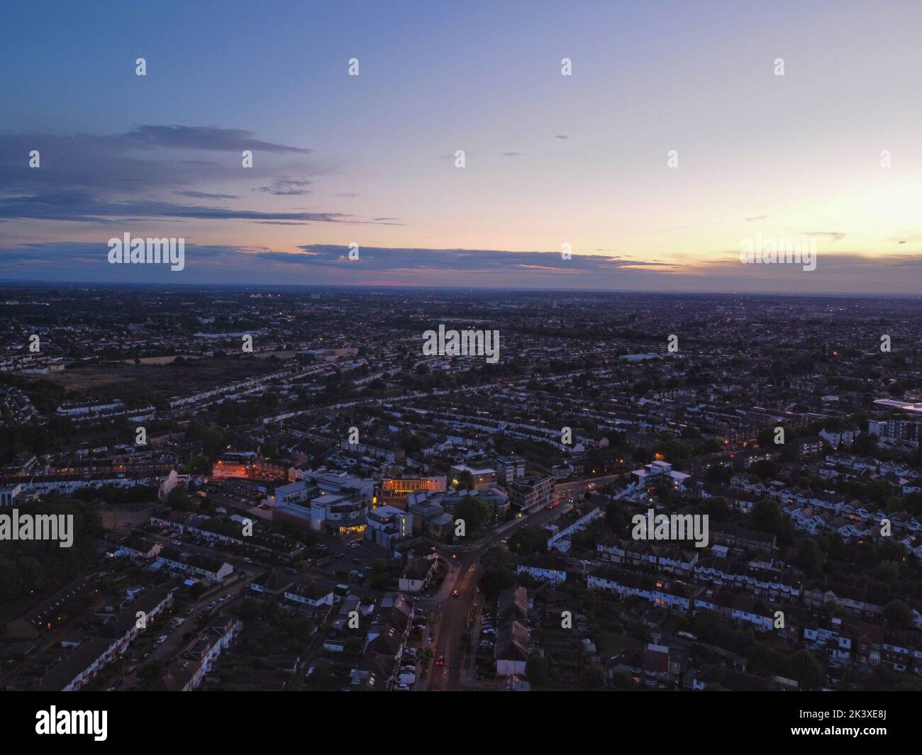 An aerial shot of an orange sunset over a modern city during nighttime ...