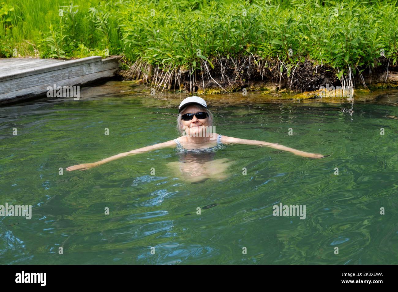 Lone senior woman enjoying Liard River Hot Springs; Liard River Provincial Park; British Columbia; Canada Stock Photo