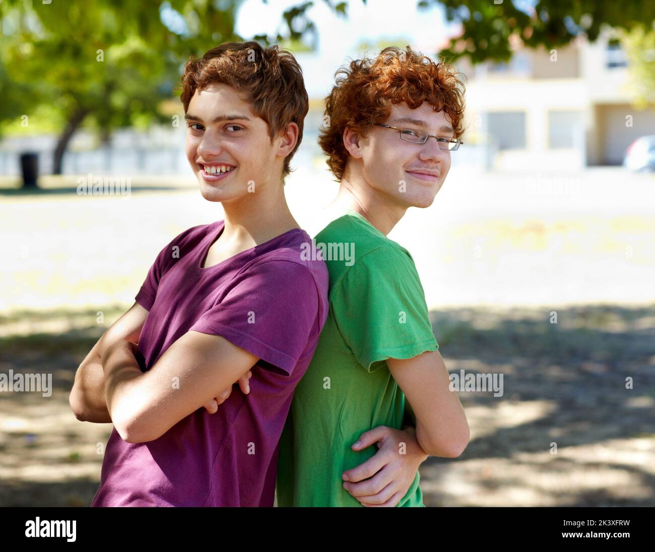 Hes got my back. Portrait of two boys standing back to back outdoors on a sunny day. Stock Photo