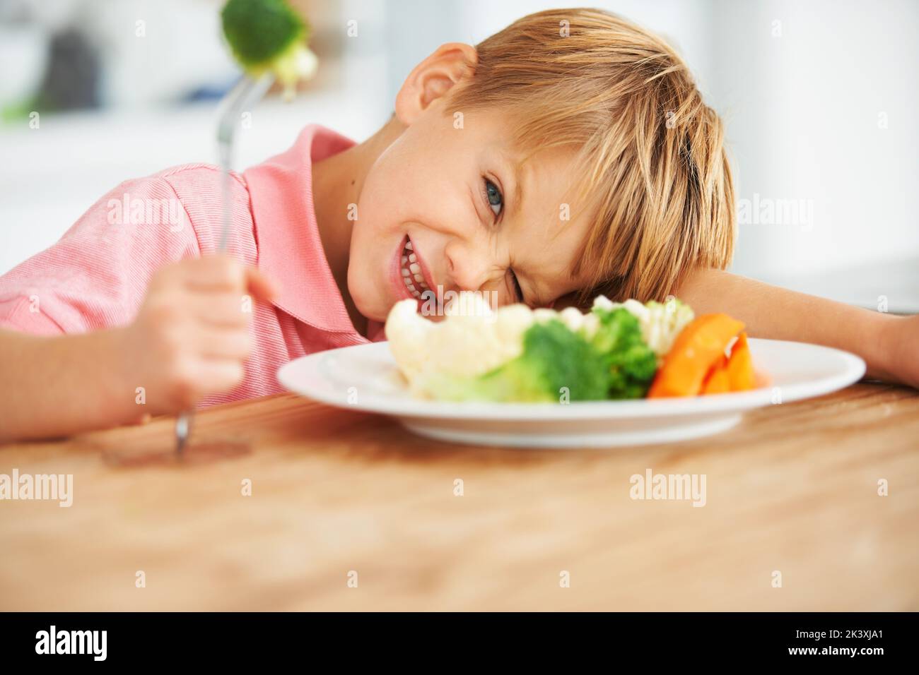 Im not eating this. A little boy very unhappy with having to eat vegetables. Stock Photo