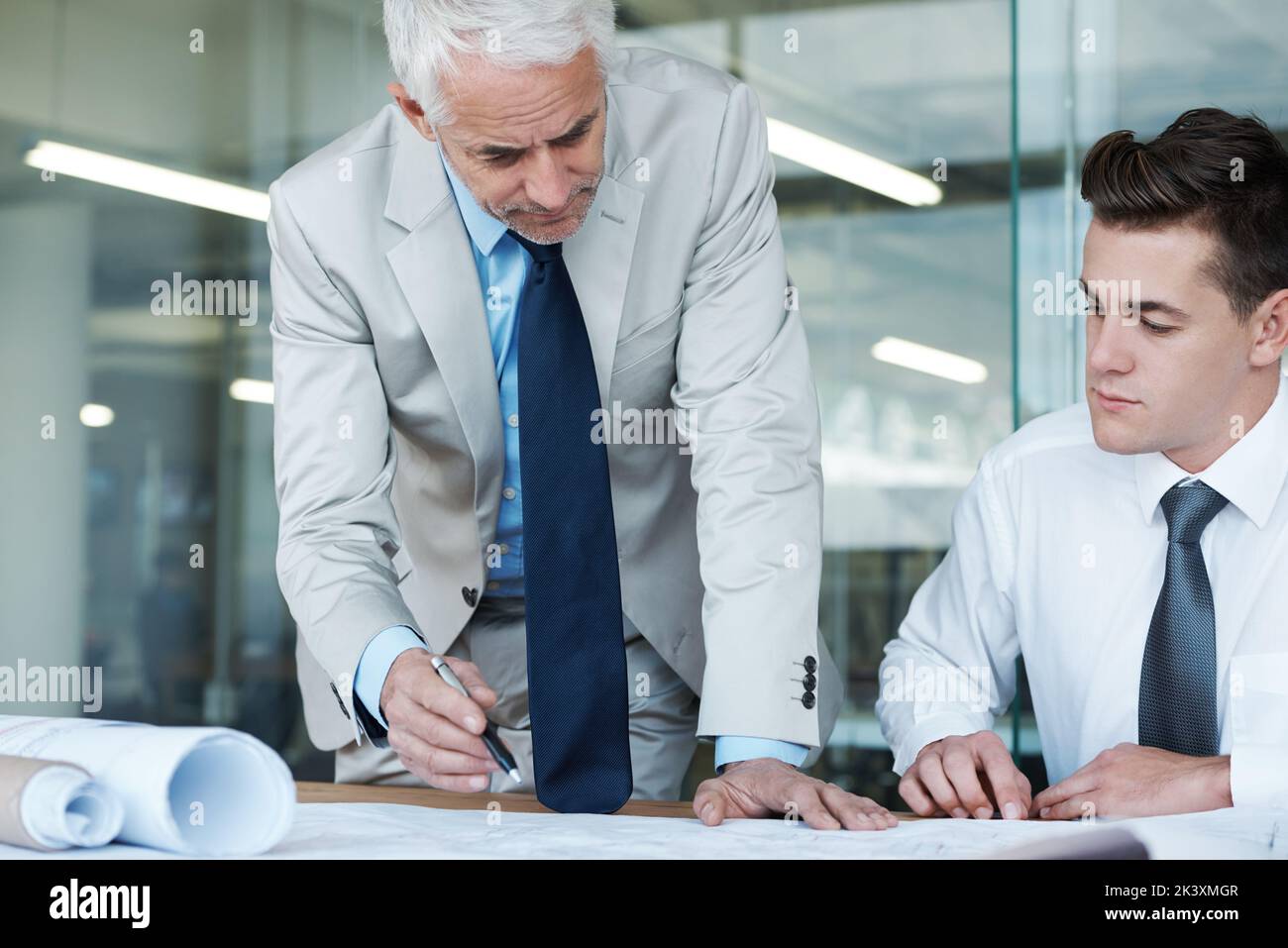 Ensuring the blueprints are perfect. two architects going over a ...