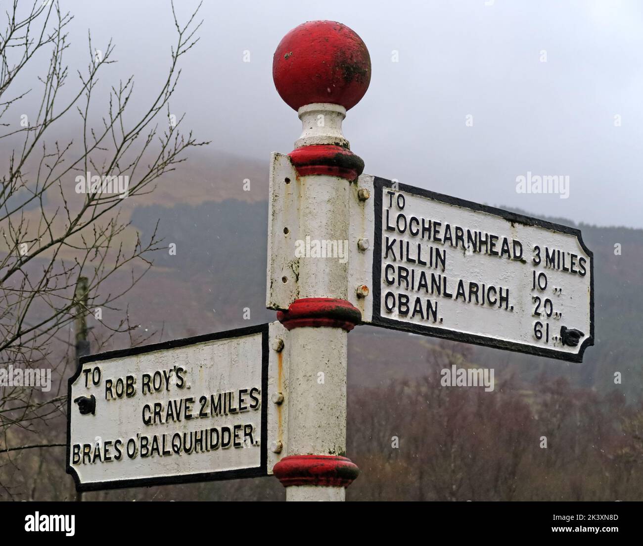 foggy Scottish road sign, fingerpost, to Rob Roys Grave, Balquhidder, Lochearnhead, Scotland, UK,  FK19 8PA, to Oban, Killin & lochearnhead Stock Photo