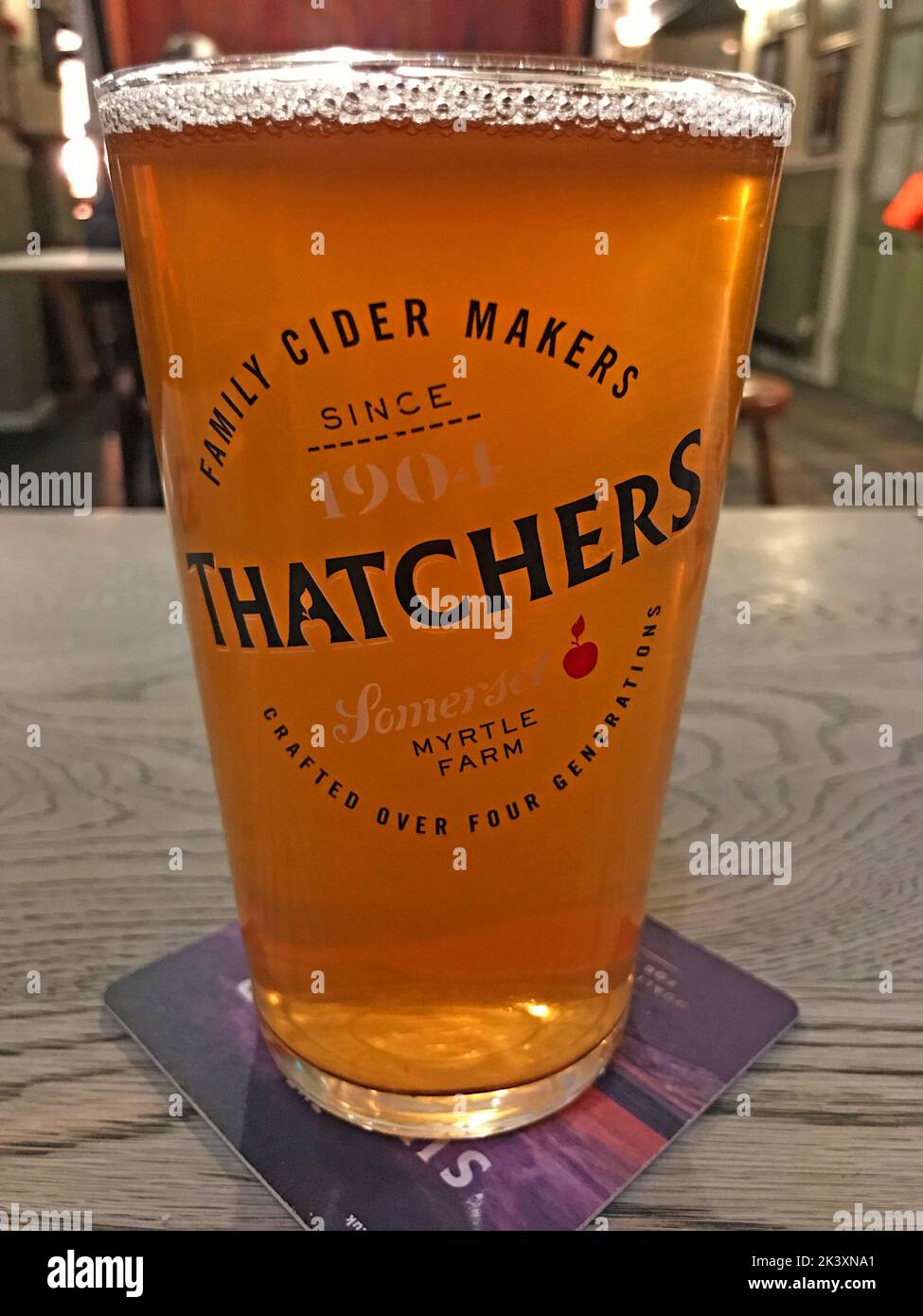 Pint of Thatcher's, Somerset Myrtle Farm Cider, in a pub table & beermat Stock Photo