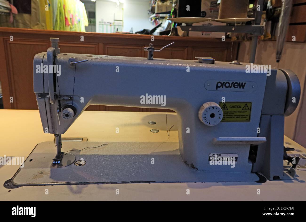 Prosew C111-3 Lockstitch (AP0280) industrial sewing machine in an empty alterations shop workshop Stock Photo