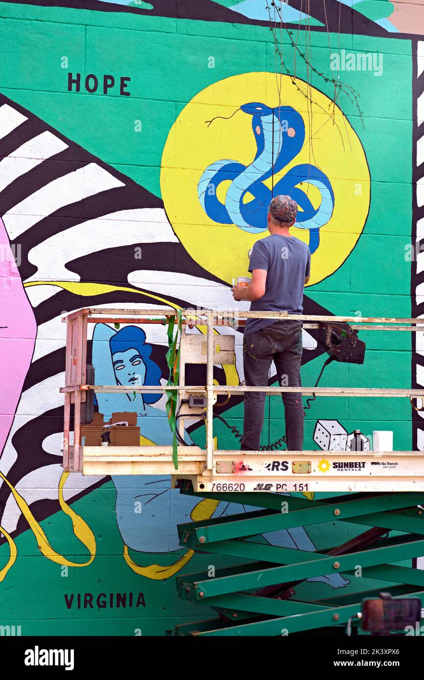 An artist creates a new mural during the 2022 RVA Street Art Festival