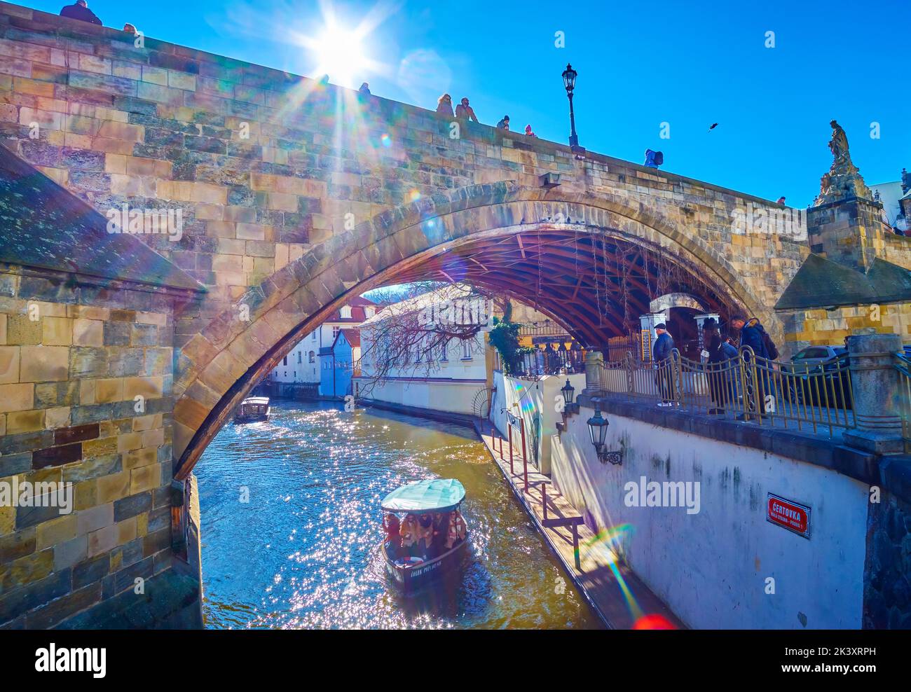 PRAGUE, CZECH REPUBLIC - MARCH 12, 2022: The boat sails along Certovka Canal under Charles Bridge, on March 12 in Prague, Czech Republic Stock Photo