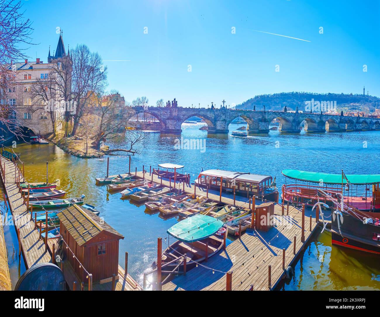 The small pier with old wooden boats and tourist ferries at Charles Bridge in the heart of Prague, Czech Republic Stock Photo