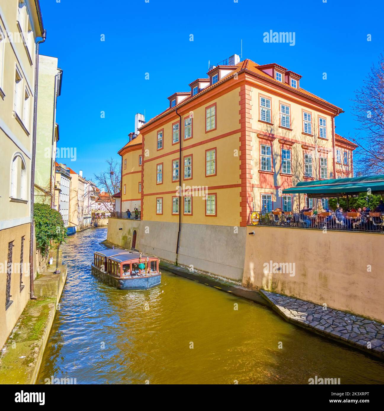 PRAGUE, CZECH REPUBLIC - MARCH 12, 2022: The tourist boat sails along Certovka Canal in Mala Strana district, on March 12 in Prague, Czech Republic Stock Photo