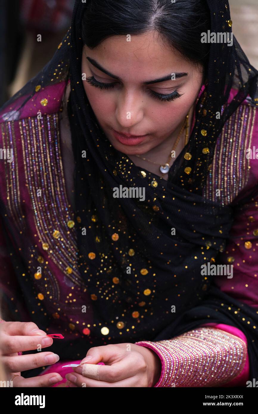 Young Woman from Abu Dhabi Preparing to Apply a Henna Design to a Young