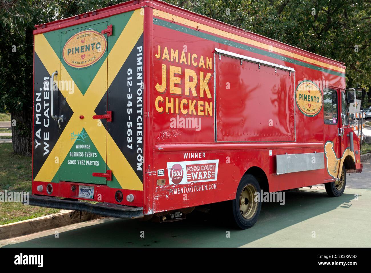 Colorful red food truck serving Jamaican Jerk Chicken near Lake Bde Maka Ska. Minneapolis Minnesota MN USA Stock Photo