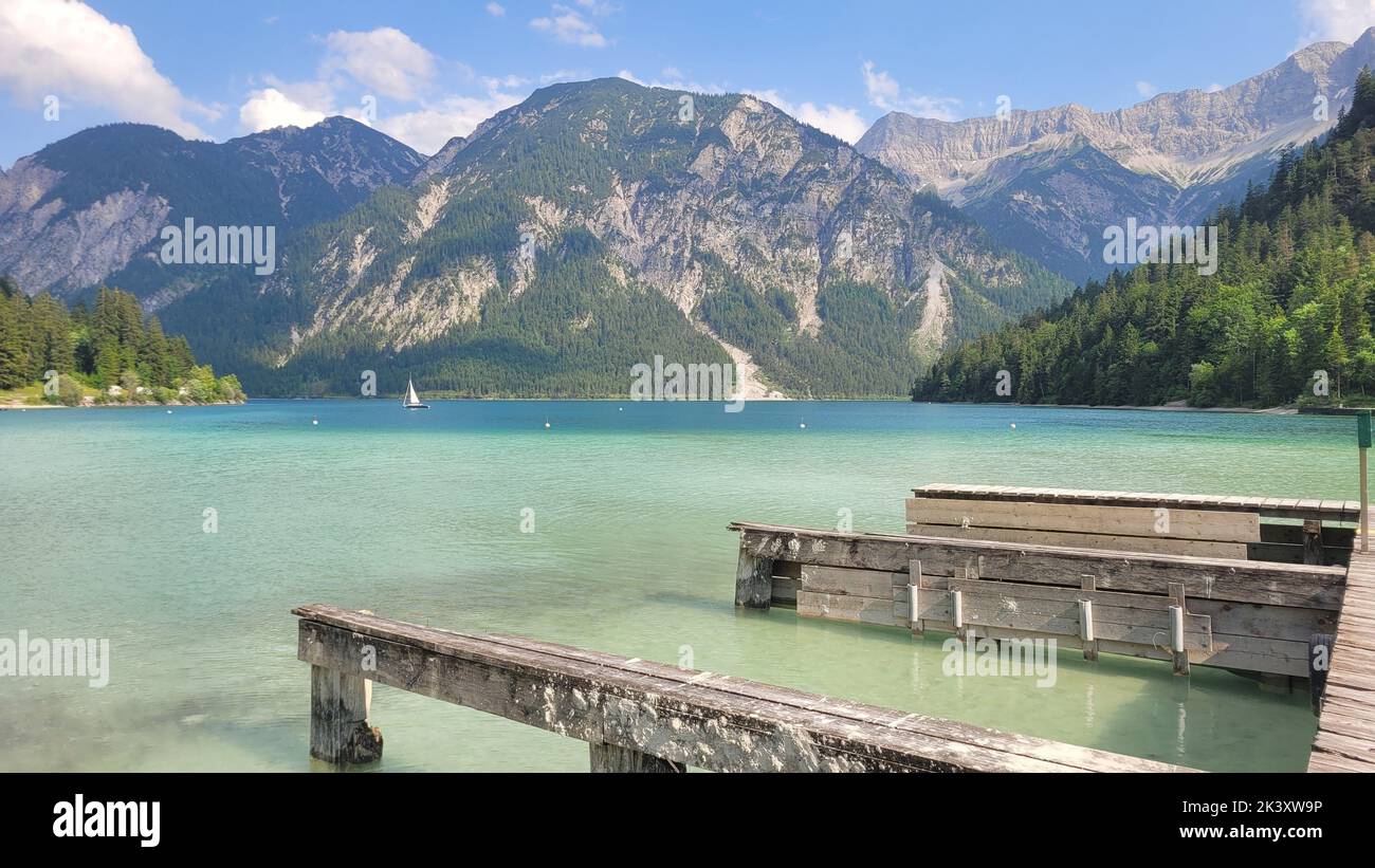 A gorgeous view of Lake Plansee in Tyrol, Austria with tall mountains ...