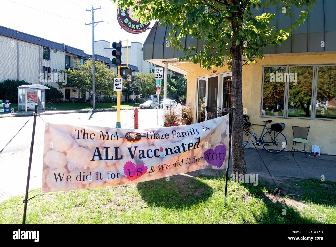 The entrance to the family owned Mel-O-Glaze Bakery with a sign saying all employees have been vaccinated for Covid. Minneapolis Minnesota MN USA Stock Photo