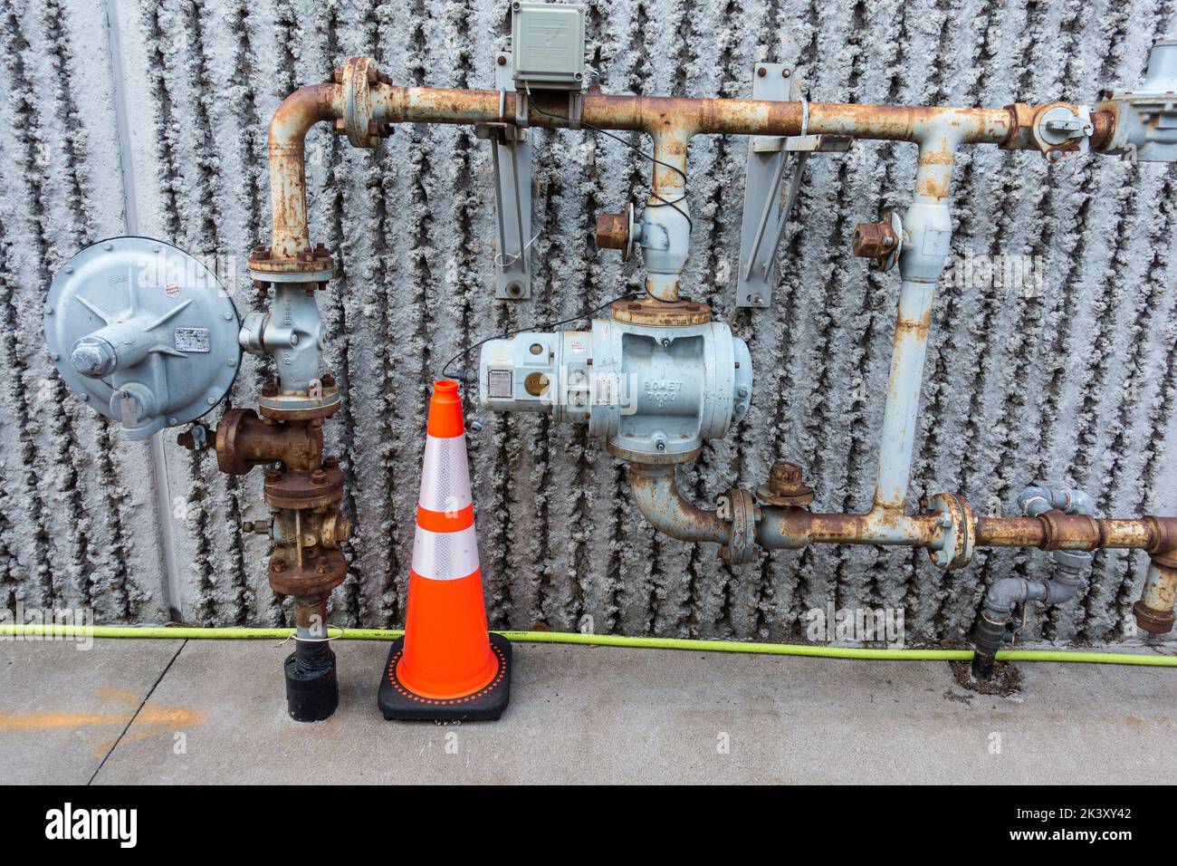 Working gas valve with connecting rusty pipes protected by an orange cone. Minneapolis Minnesota MN USA Stock Photo