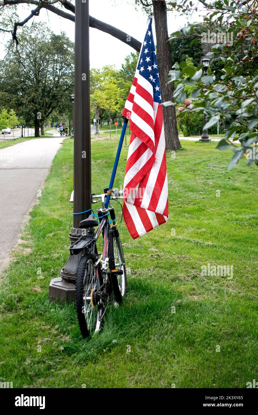 Parked bicycle supporting an American Flag. St Paul Minnesota MN USA Stock Photo