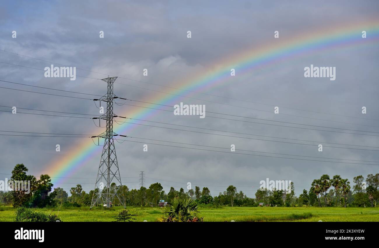 A magical rainbow over lush green paddy fields. Stock Photo