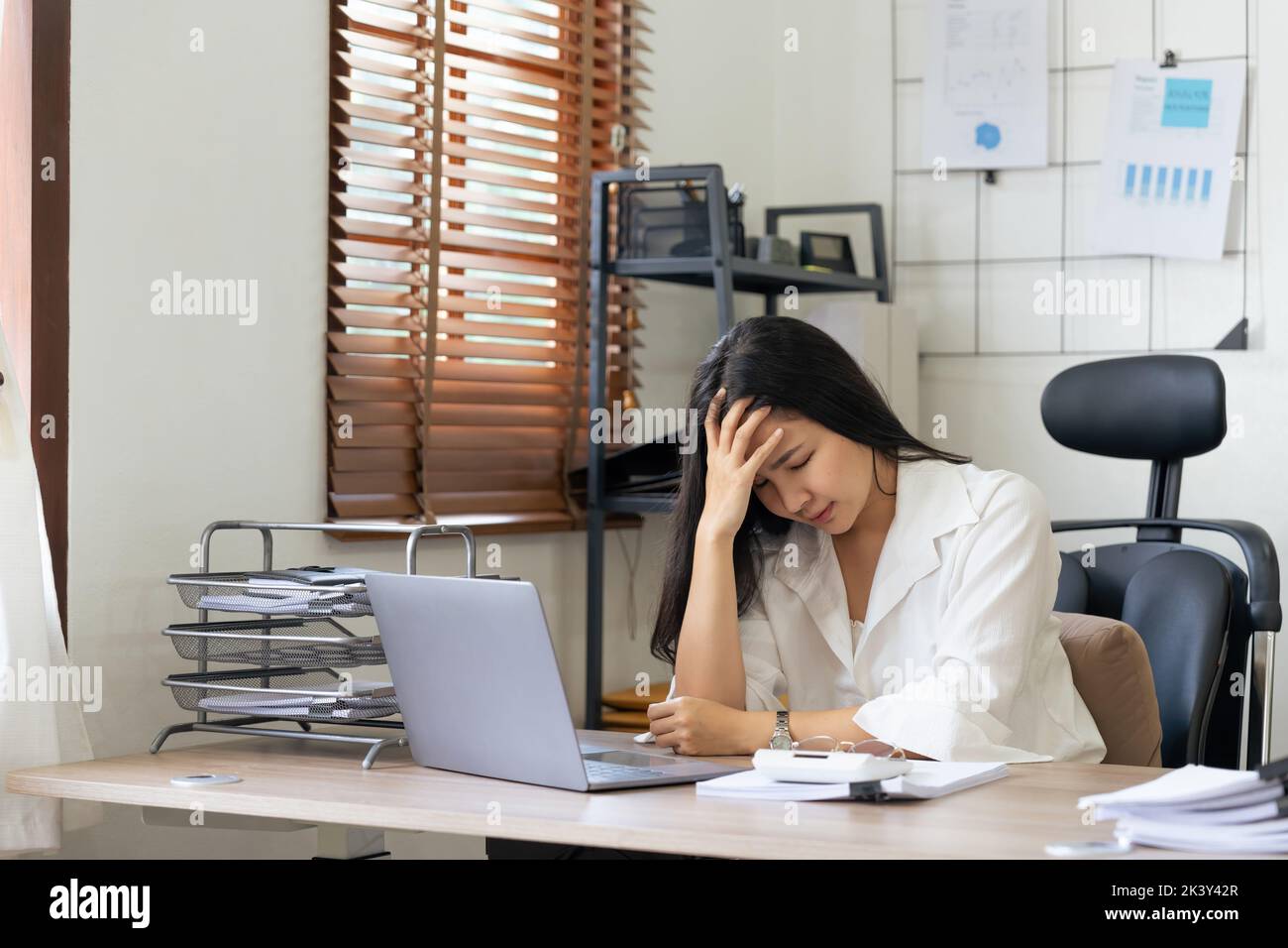 Tired business accountant woman feel headache. stressed working woman at business desk in a business office Stock Photo