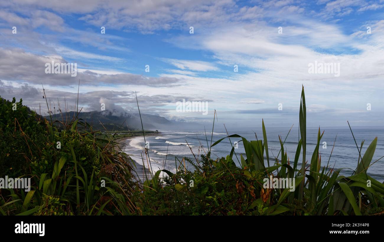 Waves tumble onto a West Coast beach near Karamea in Aotearoa New Zealand's South Island. Stock Photo