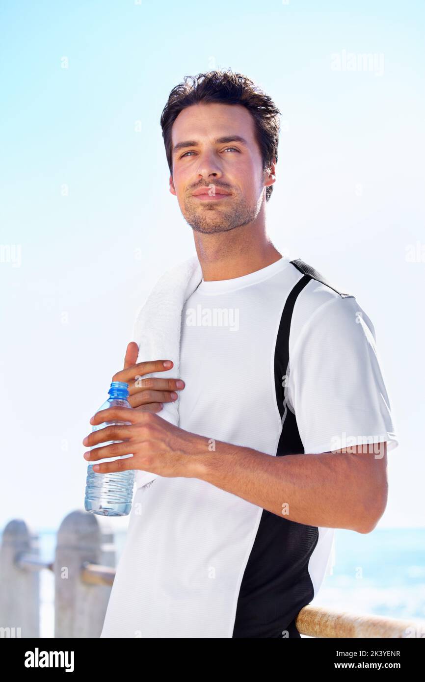 Keeping hydrated. A fit young man taking a water break while exercising