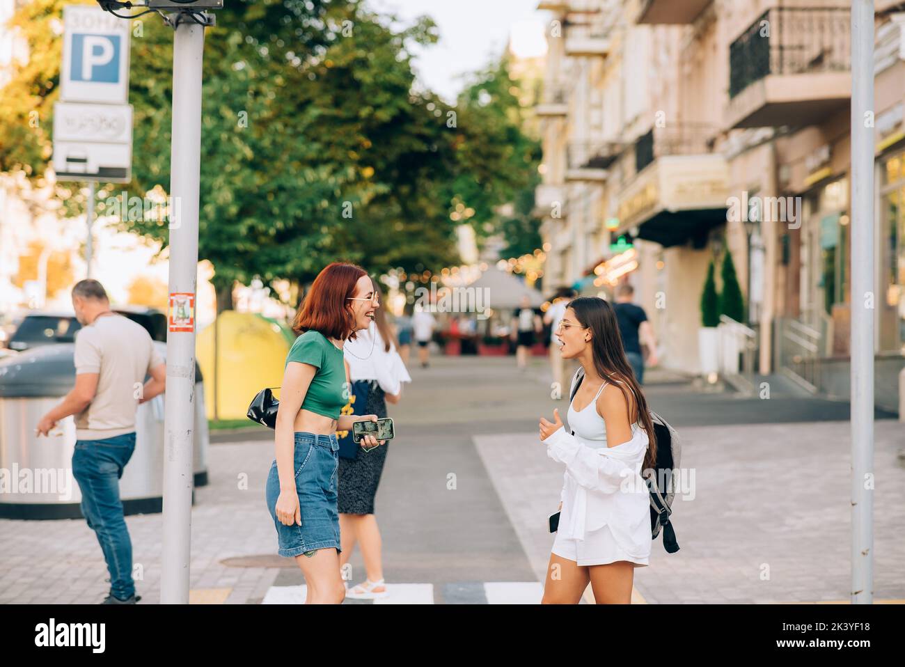 Happy women talking and laughing at the city street Stock Photo - Alamy