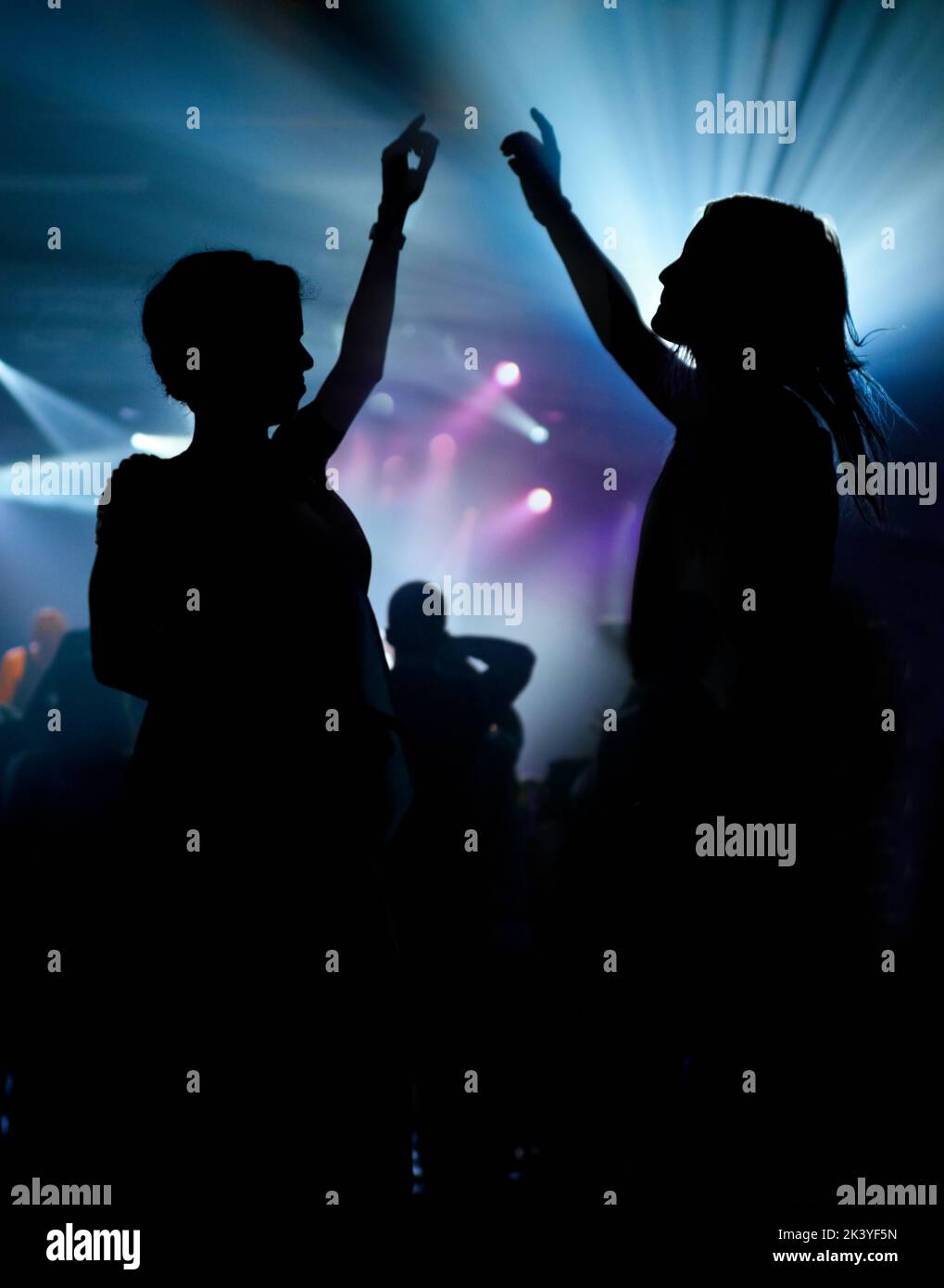 two women enjoying the music at a concert. This concert was created for the sole purpose of this photo shoot, featuring 300 models and 3 live bands Stock Photo