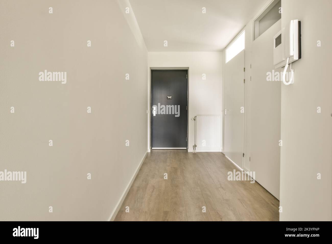 Interior of narrow corridor with telephone , radiator and many doors in ...