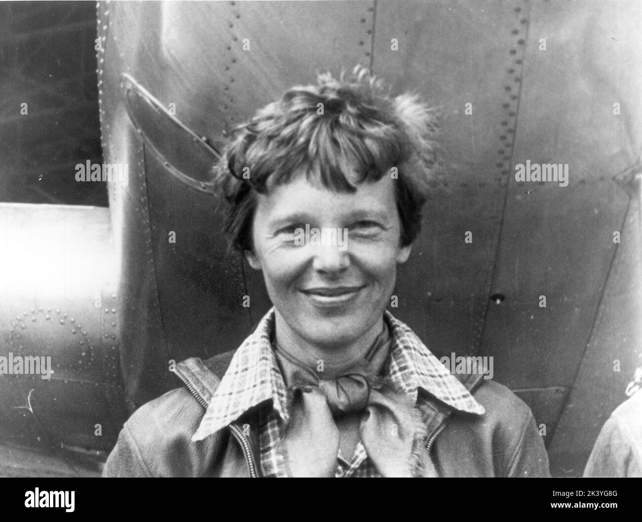 Amelia Earhart standing under nose of her Lockheed Model 10-E Electra - 1937 Stock Photo