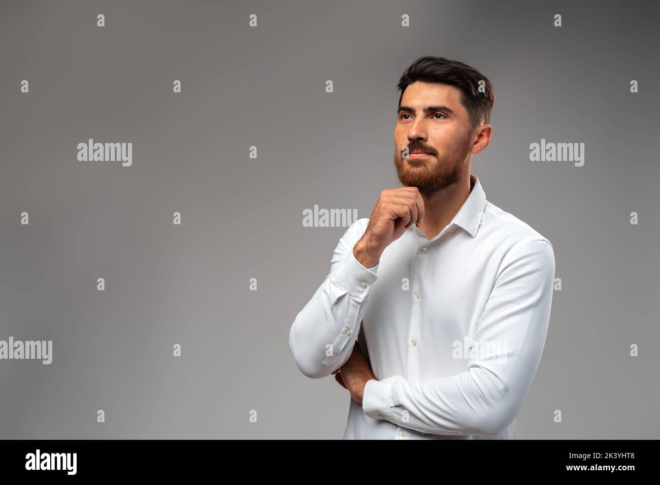 Studuo shot of thinking businessman standing over gray background Stock Photo