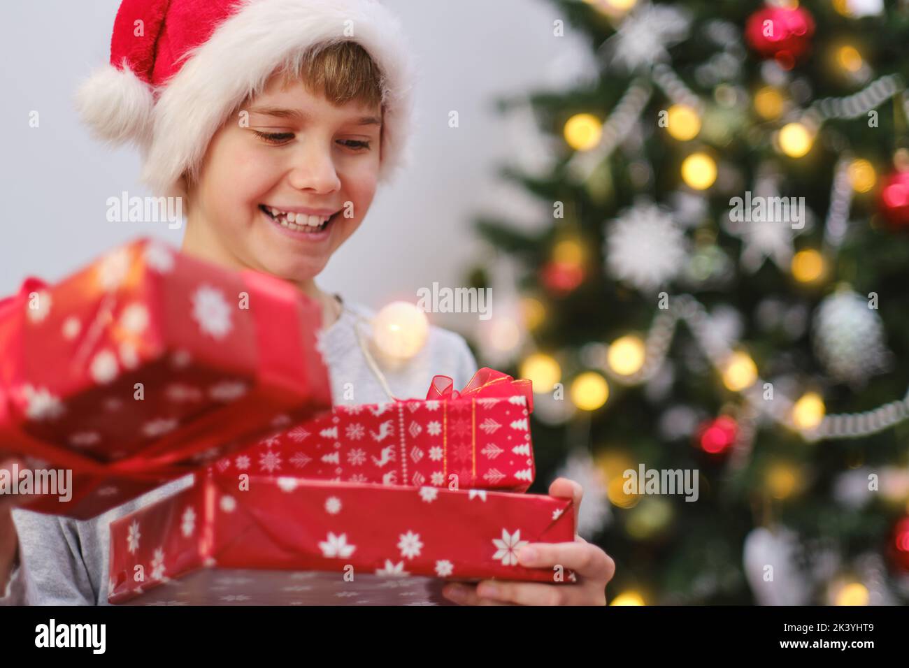 Cheerful boy holding his presents on a Christmas morning. Stock Photo