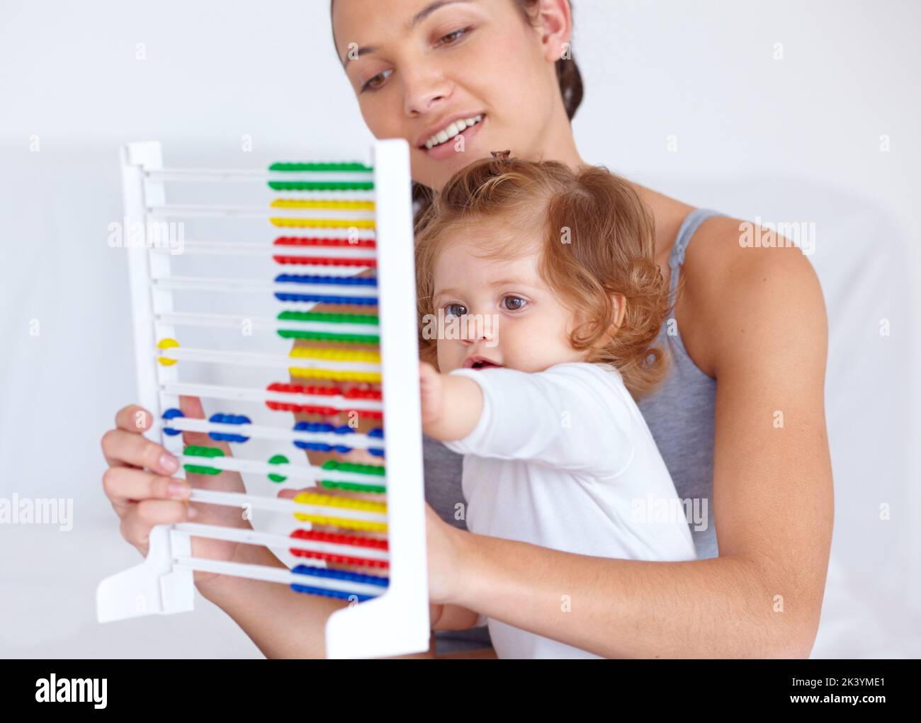 Learning at home a young mother teaching her baby daughter the basics