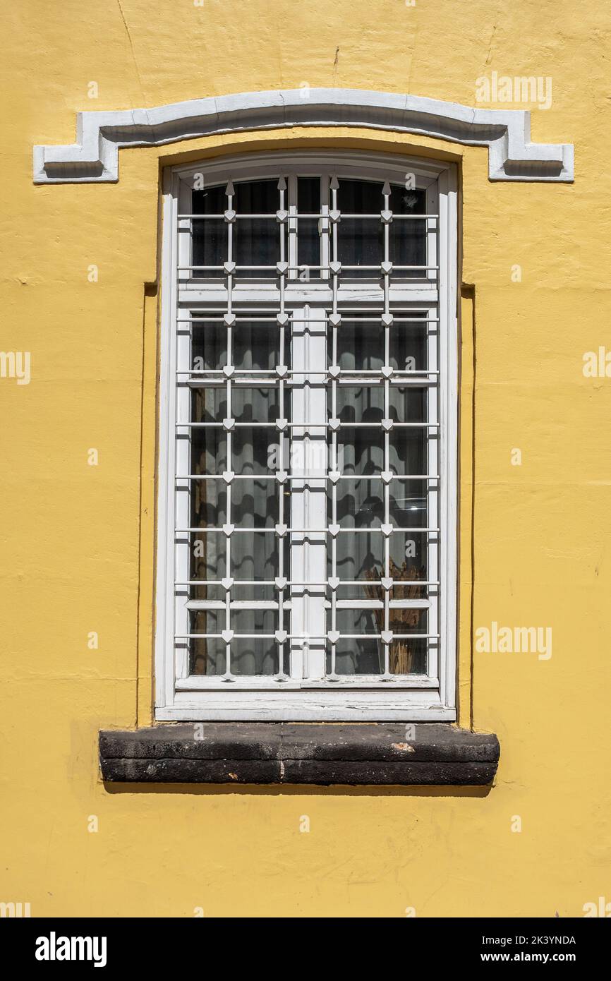 An old classic yellow stucco painted house wall with windows. Calssic buildings and windows textures. High quality photo Stock Photo