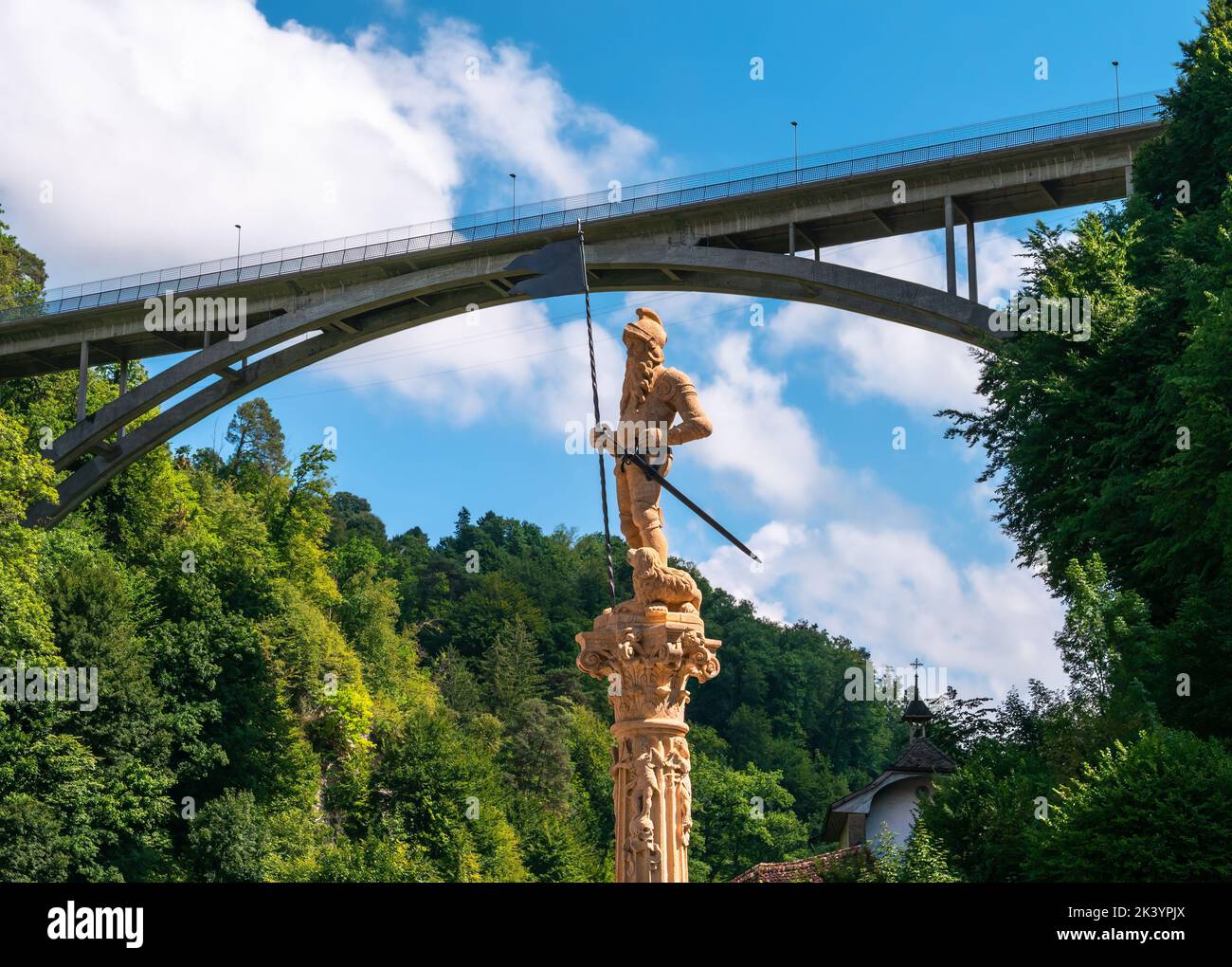 Fribourg, Switzerland - August 31, 2022: A modern highway viaduct over a historic knight statue in the old town of Fribourg, Switzerland Stock Photo