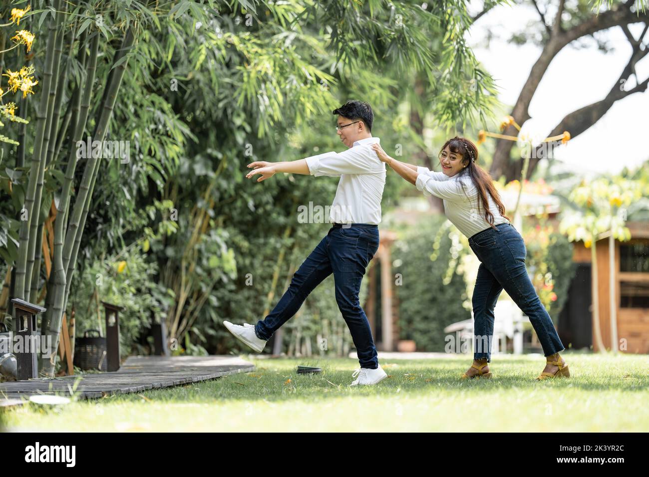 Asian Woman Grabbing and Catching Man shoulder and bracing the man to ...
