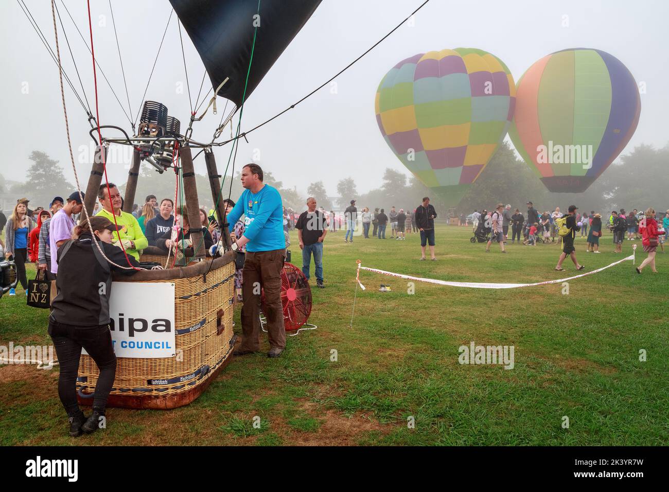 Hot air balloons on a misty day. In the foreground is a pilot in his