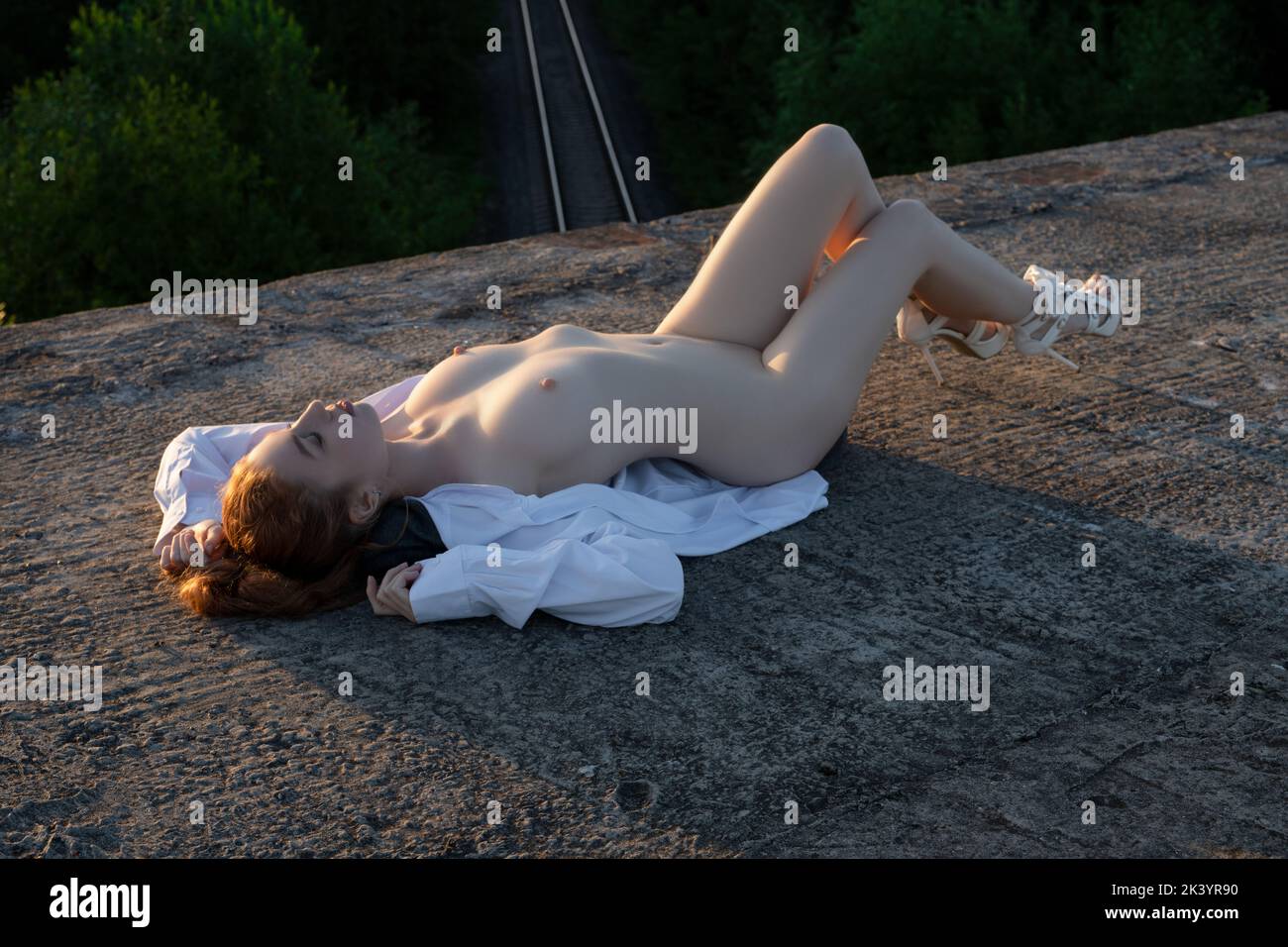 Relaxed woman lying on bridge over railway Stock Photo