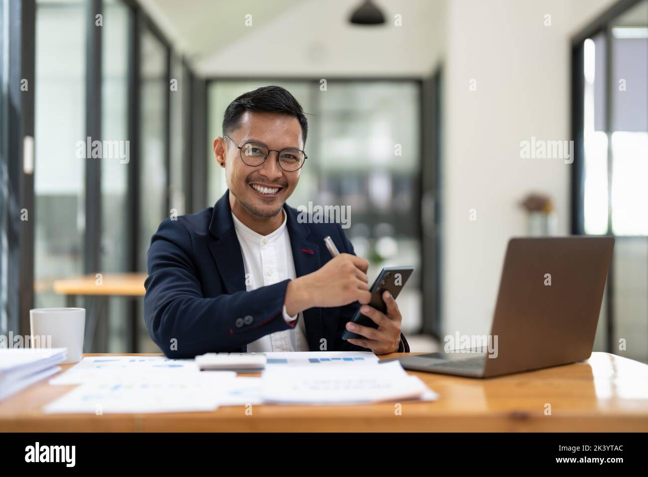 Portrait of a business man using mobile phone. asian business men working with laptop at office. Stock Photo